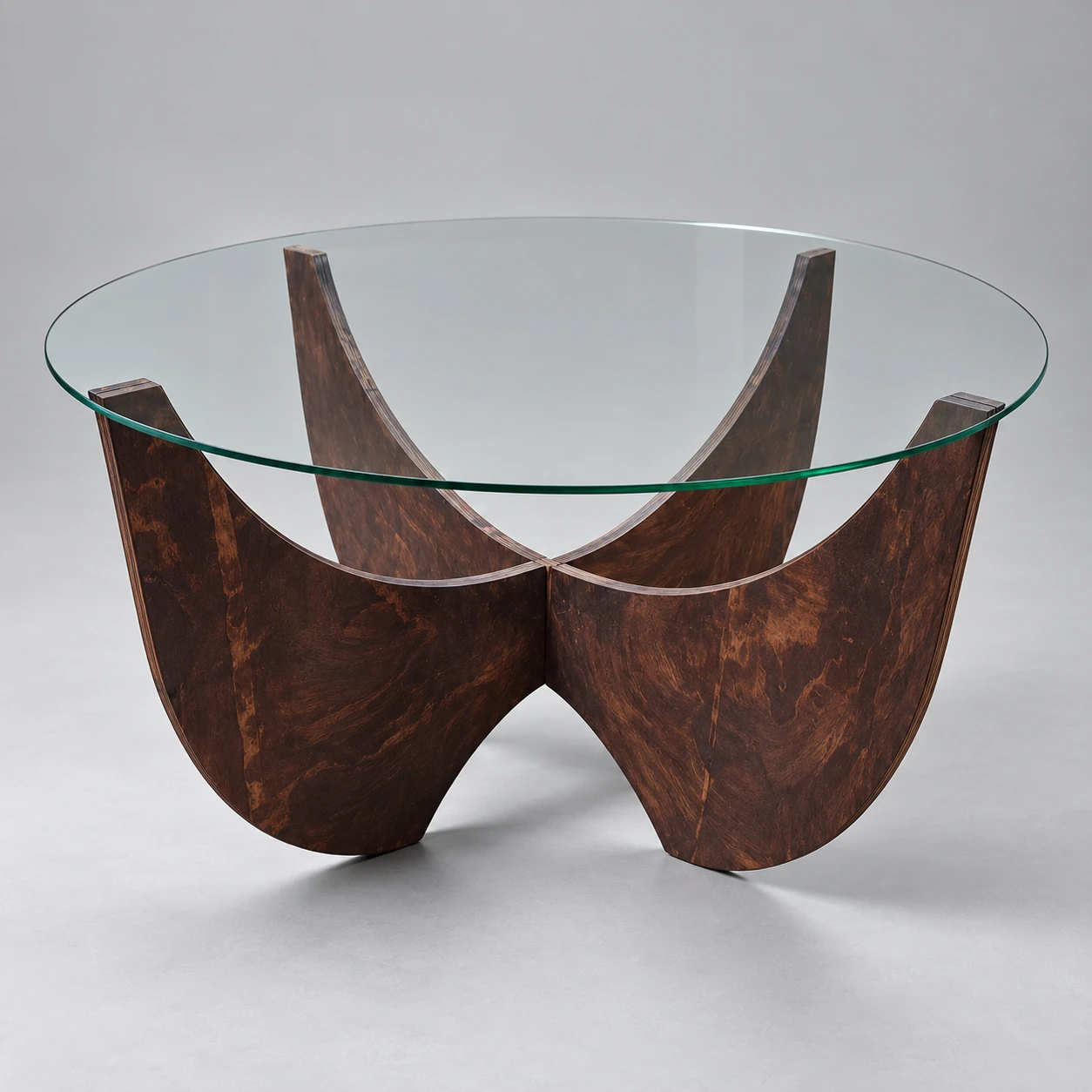 Qhathizwe circular clear-glass table with a dark timber curved cross-panel wooden base
